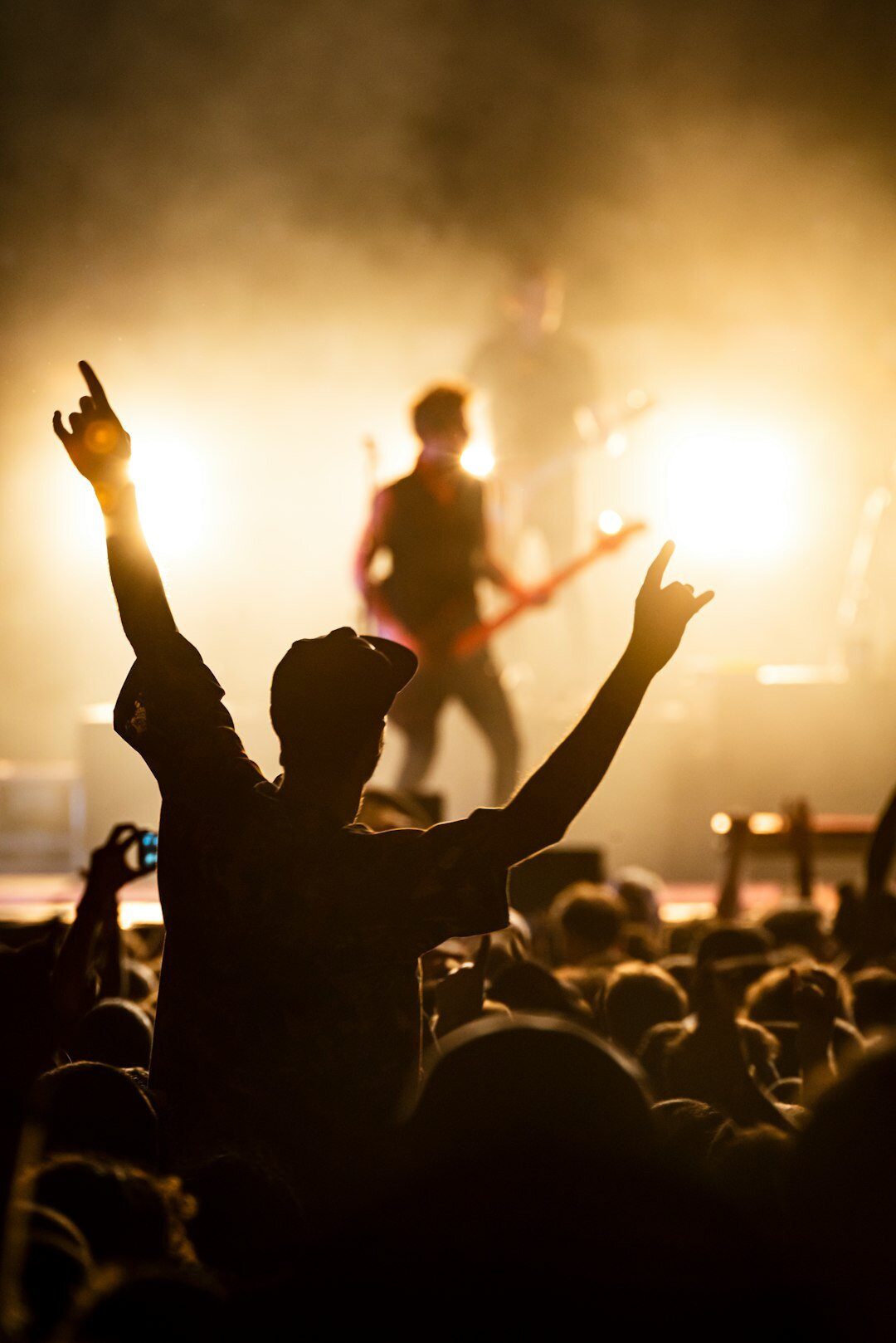 Concert stage with warm spotlight and silhouette of musician